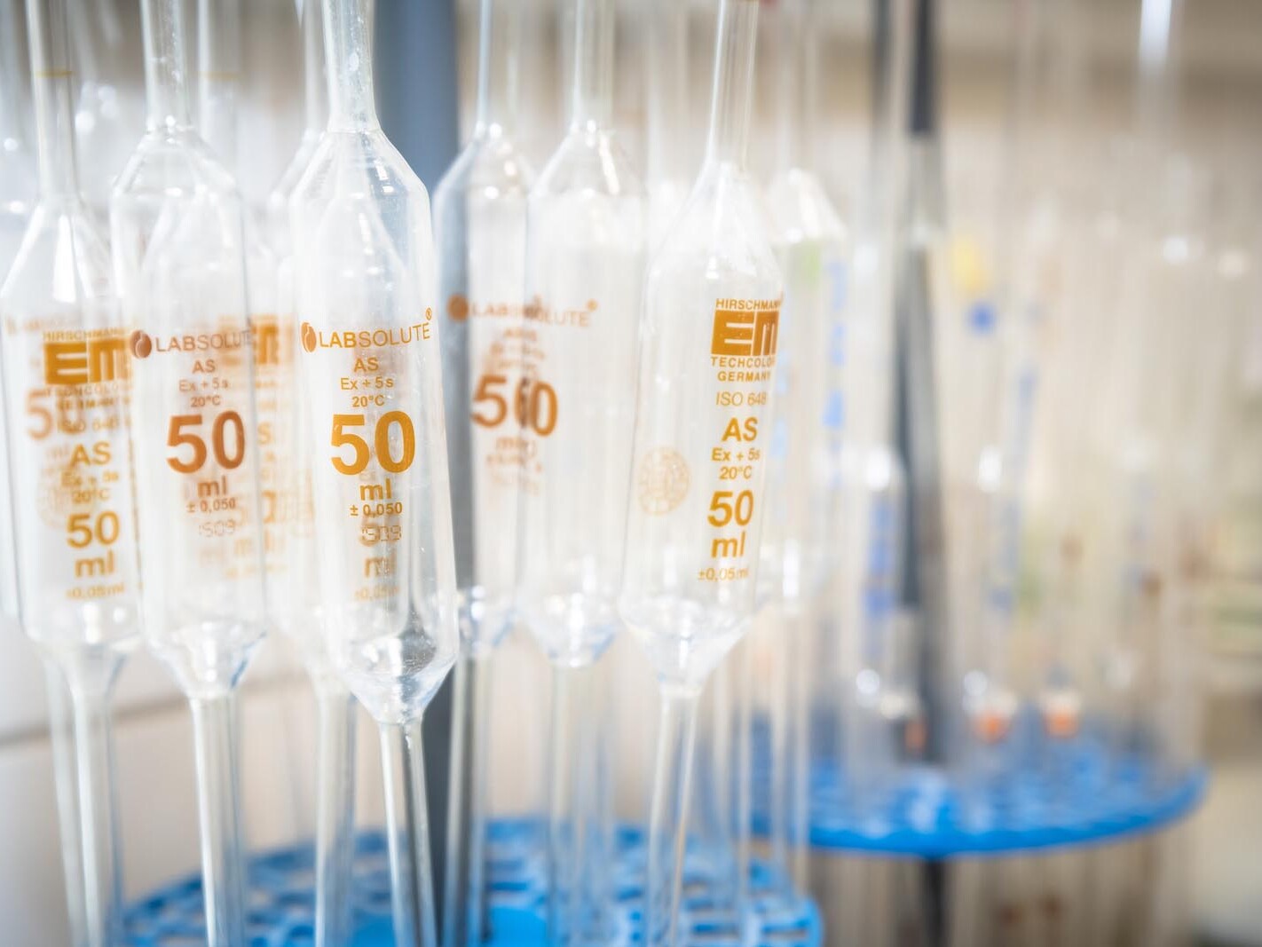 Close-up of calibrated 50 ml laboratory measuring cylinders with printed markings in a science lab